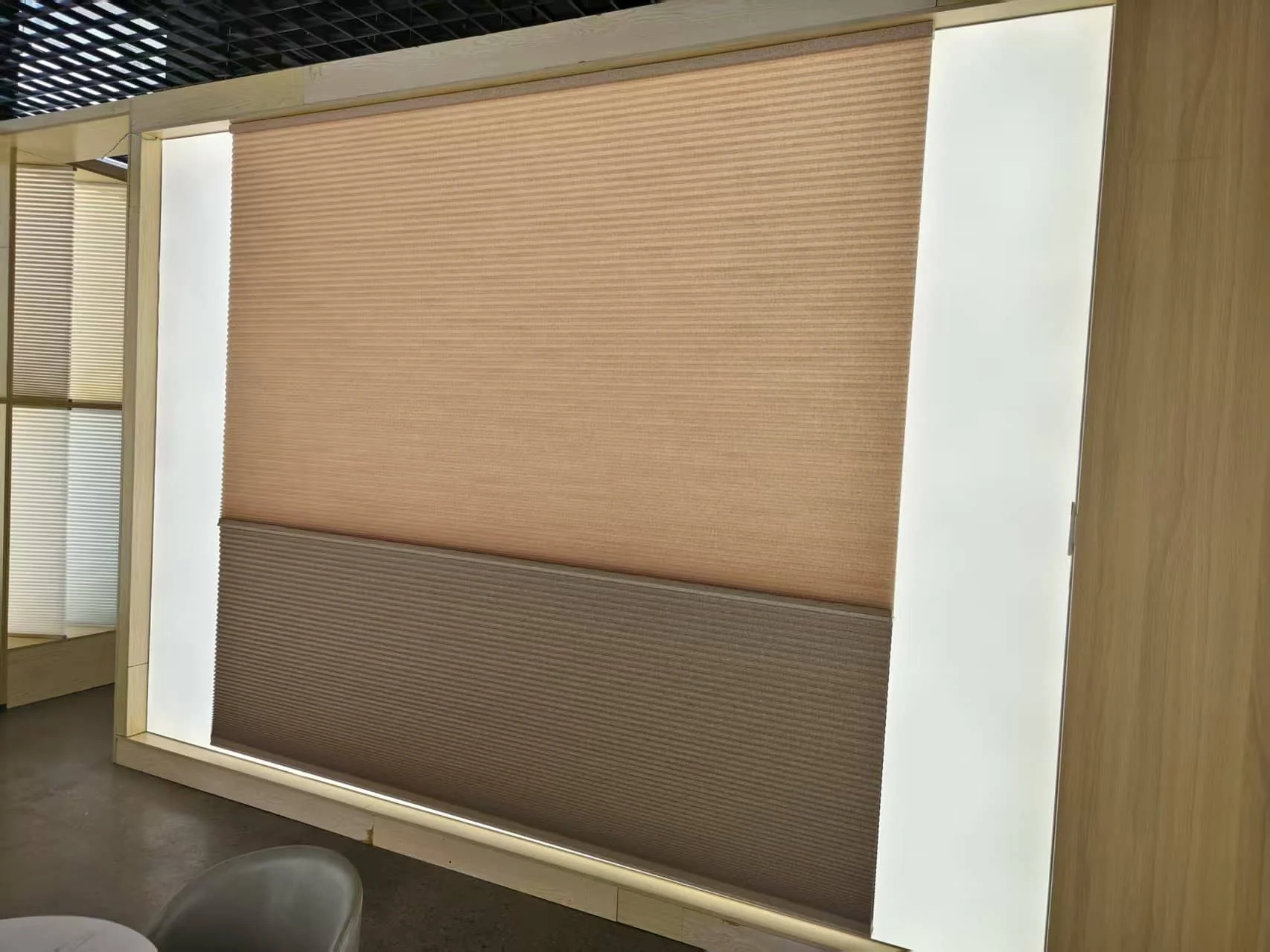 Day-night honeycomb shade sample in a timber frame on a lightbox